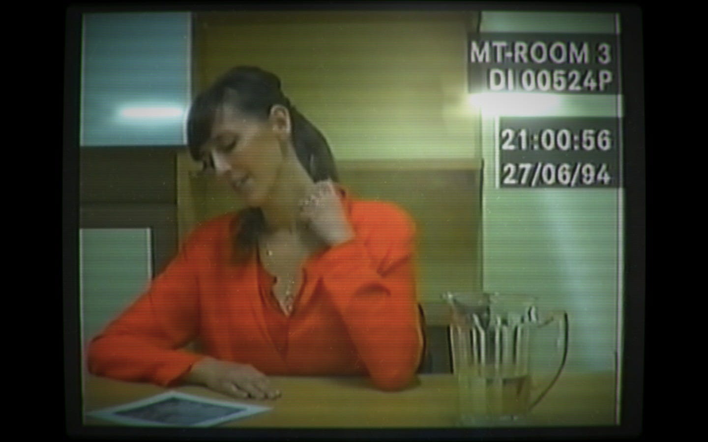 A screenshot from the game Her Story showing the subject of the interview on a CRT style display