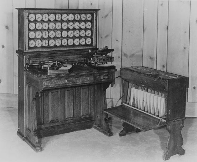 Two pieces of wooden cabinetry with a device to punch cards, many dials, and a sorter