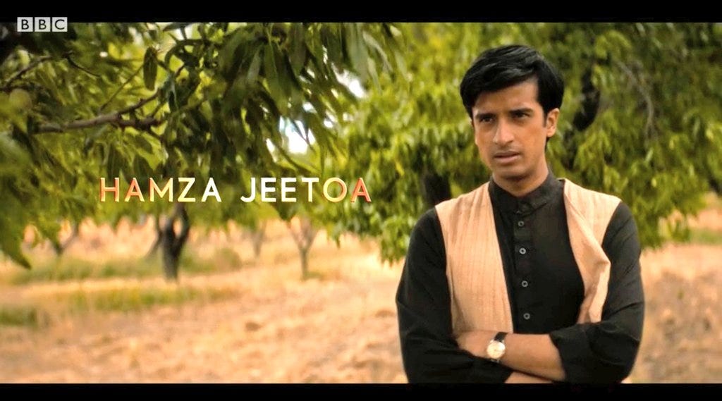 This image shows an official British Broadcasting Corporation (BBC) promotional image of the actor Hamza Jeetooa as the character Manish in "Demons of the Punjab" (Doctor Who Series 11's sixth episode). Jeetooa's full name appears on the left--with his surname misspelled (as "Jeetoa"), while the actor himself (in costume as Manish) appears on the right. This image shows an official British Broadcasting Corporation (BBC) promotional image of the actor Hamza Jeetooa as the character Manish in "Demons of the Punjab" (Doctor Who Series 11's sixth episode). Jeetooa's full name appears on the left--with his surname misspelled (as "Jeetoa"), while the actor himself (in costume as Manish) appears on the right.