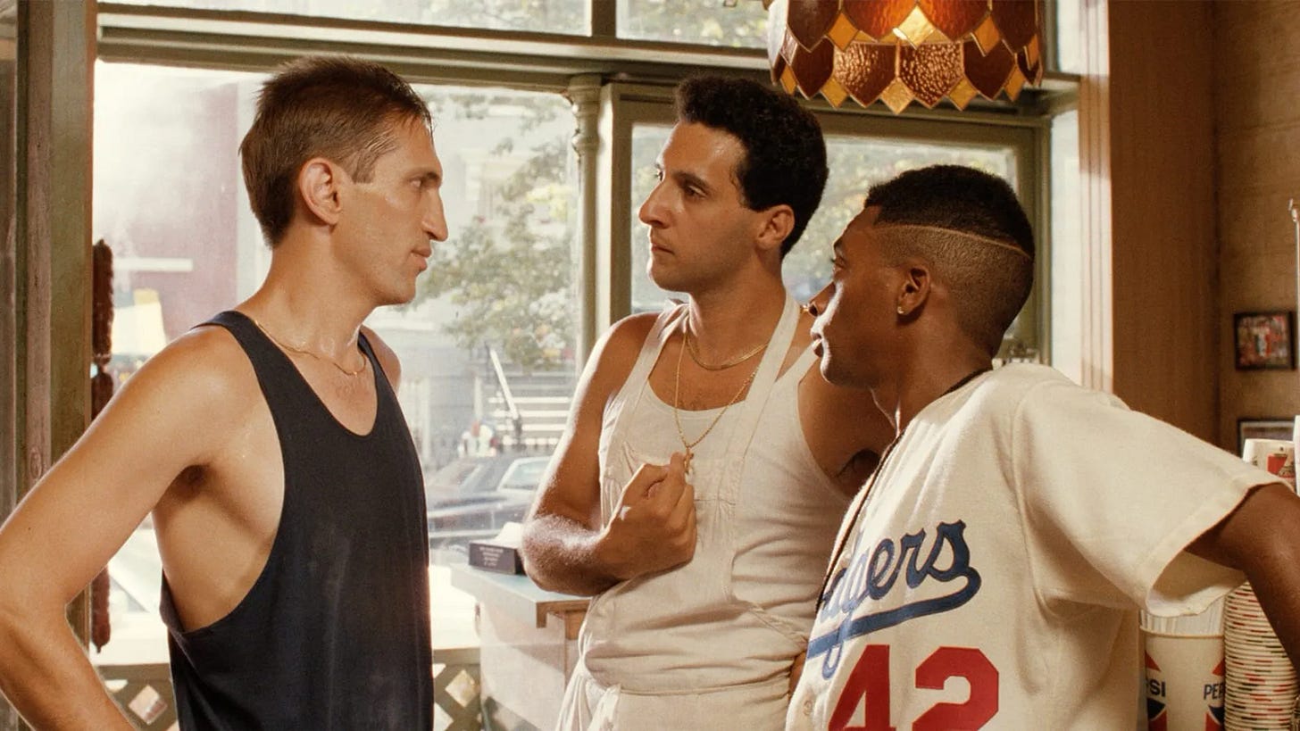 This image shows the three regular employees of Sal's Famous Pizzeria in Spike Lee's 1989 film Do the Right Thing: (left to right) Vito Frangione (played by Richard Edson), Pino Frangione (played by John Turturro), and Mookie (played by Spike Lee).