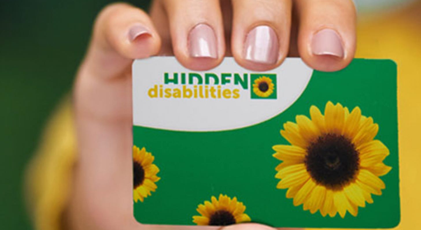 woman's hand holding up Hidden Disabilities card