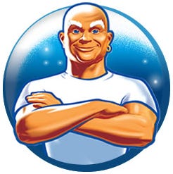 The smiling bald guy, wearing a white T-shirt, with his muscular arms crossed over his chest.