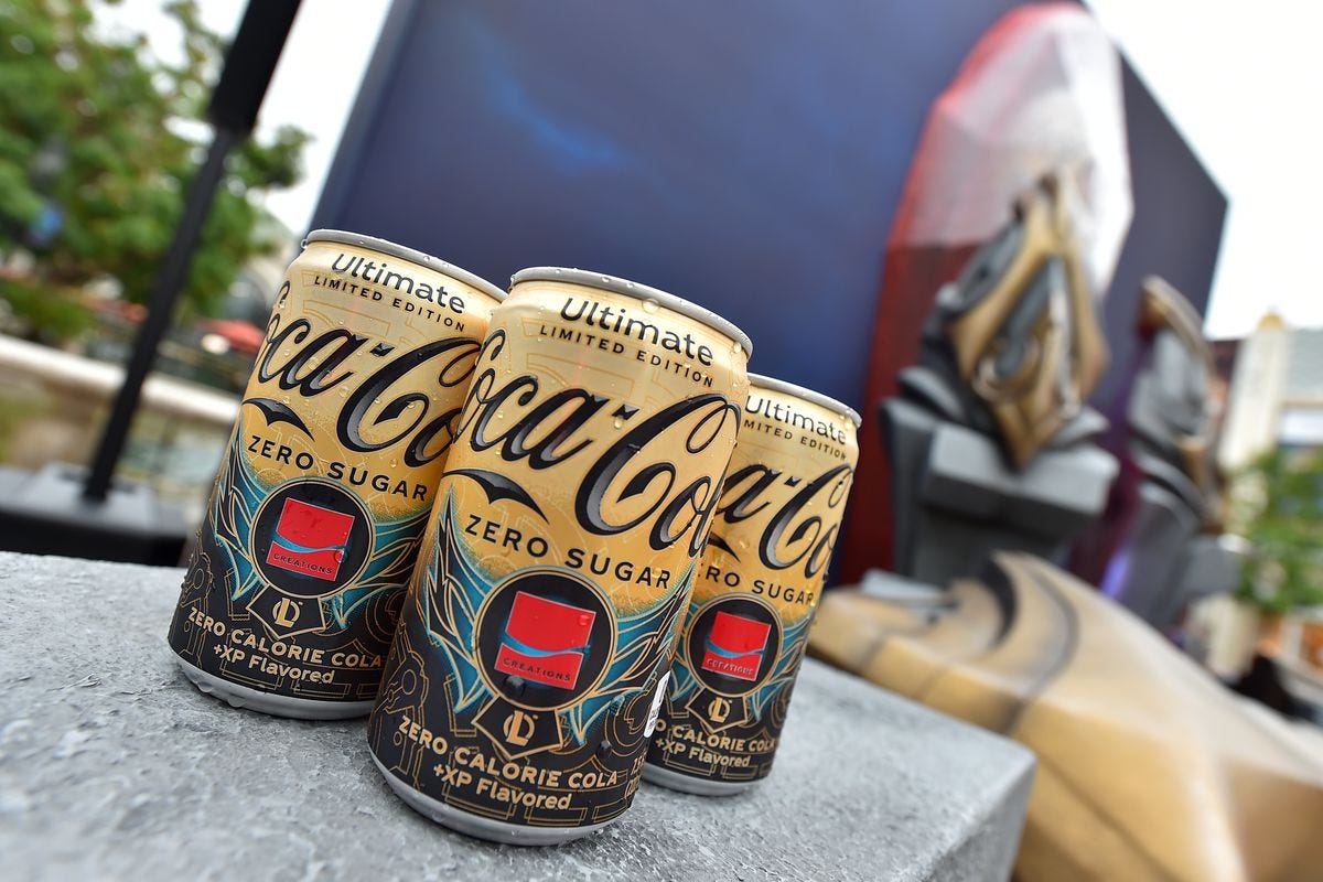 Three cans of the new +XP Coca-Cola flavor made in collaboration with Riot Games