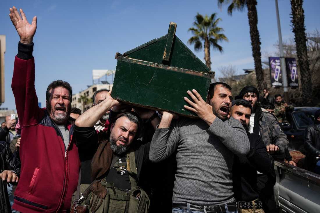 Syrian fighters and civilians carry the coffin of a member of the Syrian security forces during his funeral in Hama province on March 9.