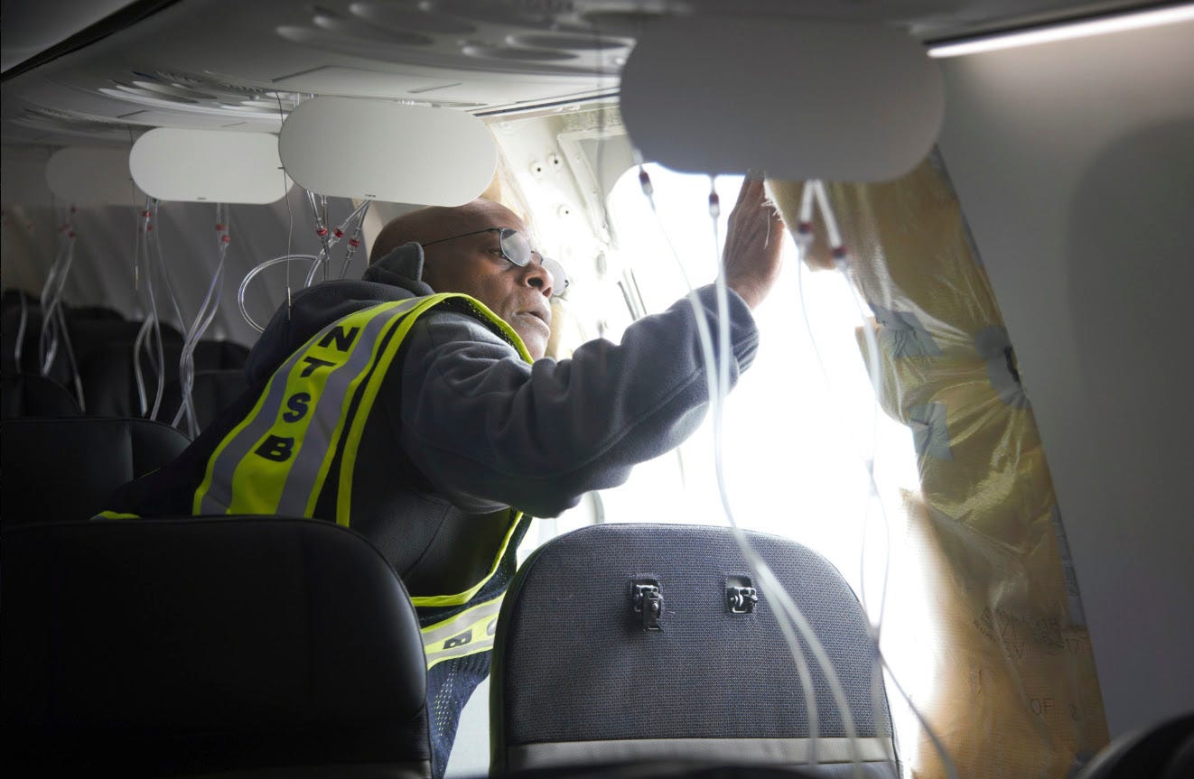 Investigator inspects the plug area near a blown out window of a plane.
