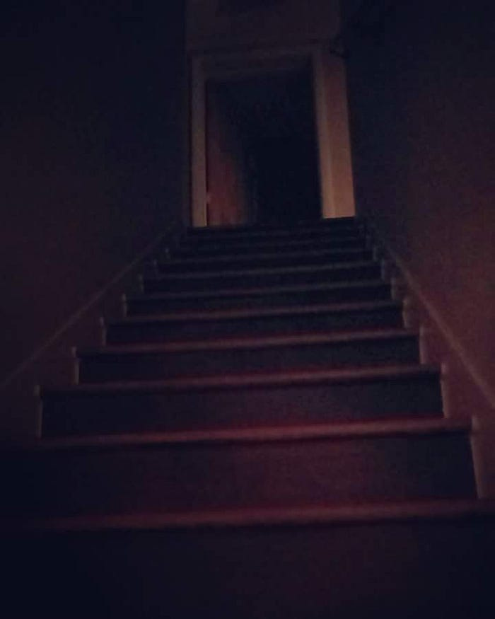 Dark, grainy picture of a staircase.