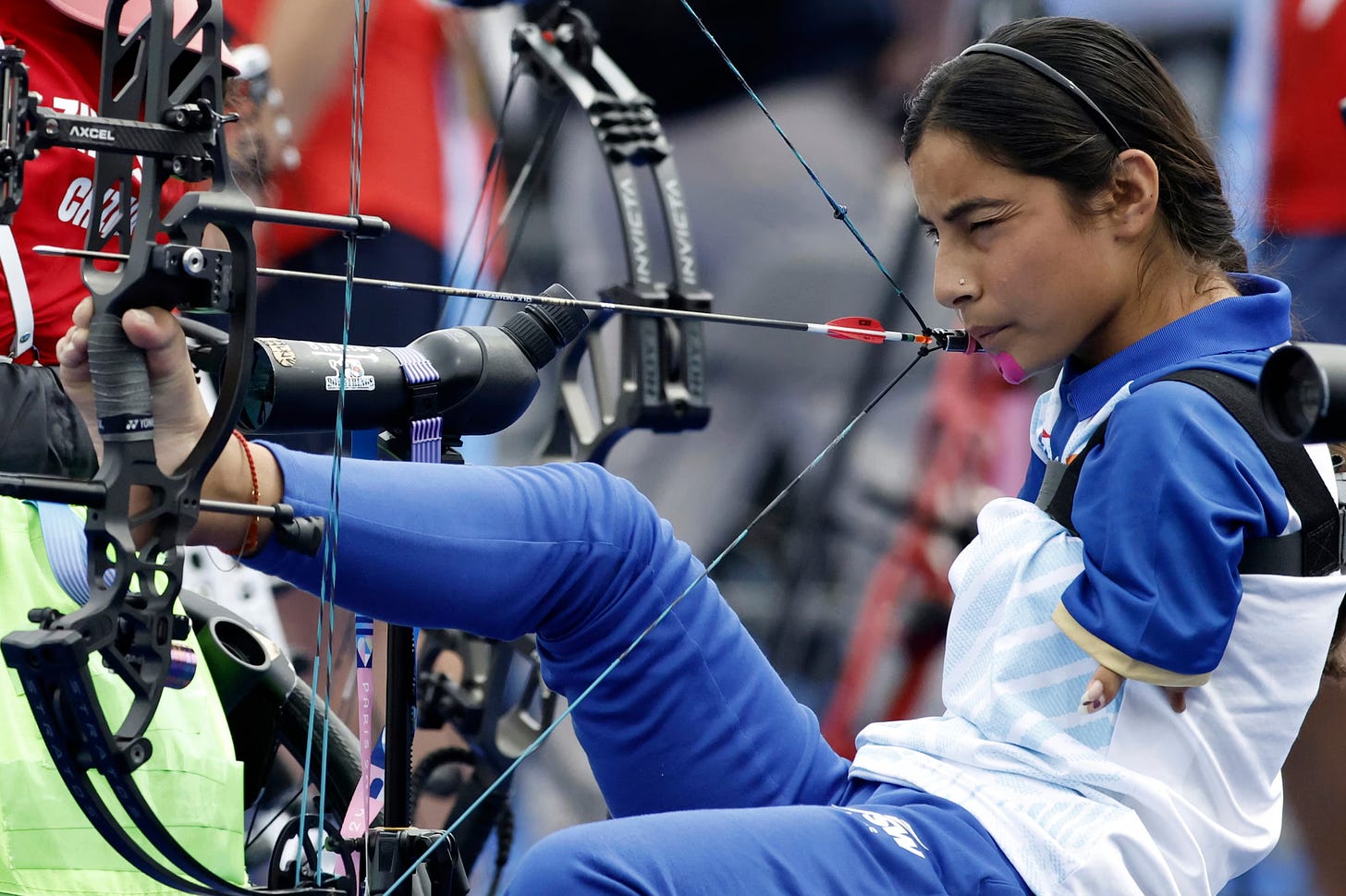 Image shows Paralympic Archer Sheetal Devi represents India in the 2024 Paralympic Games in Paris. She carefully takes aim.