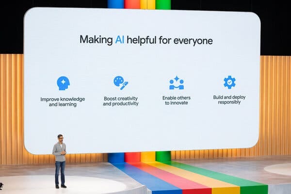 Sundar Pichai, in a gray sweater and blue jeans, stands on stage, with a large screen behind him. At the top of the screen, it says, "Making AI helpful for everyone."