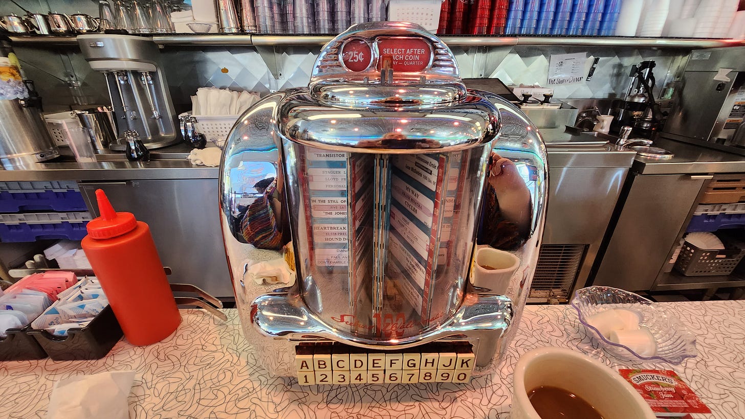 Photograph of a shiny counter-top juke box in a diner.