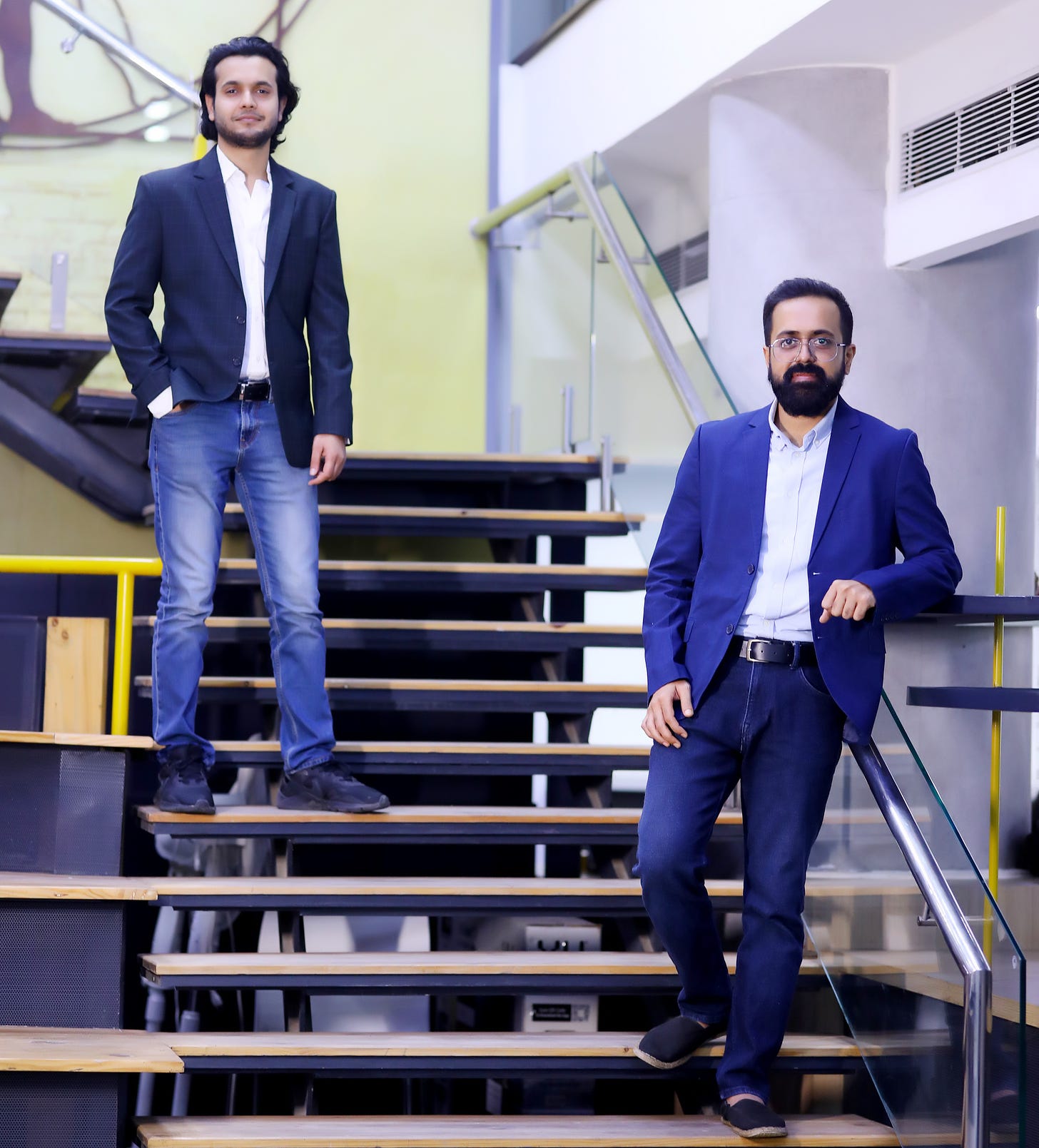 The co-founders of Legistify standing on a staircase