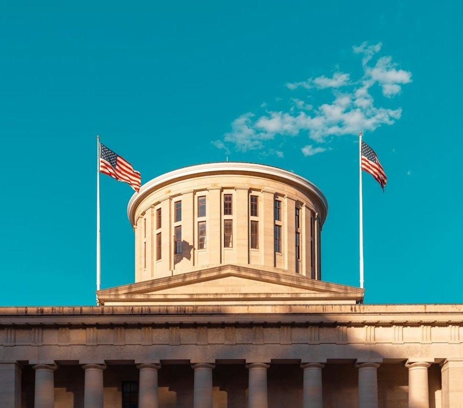 a building with two flags on top of it a building with two flags on top of it
