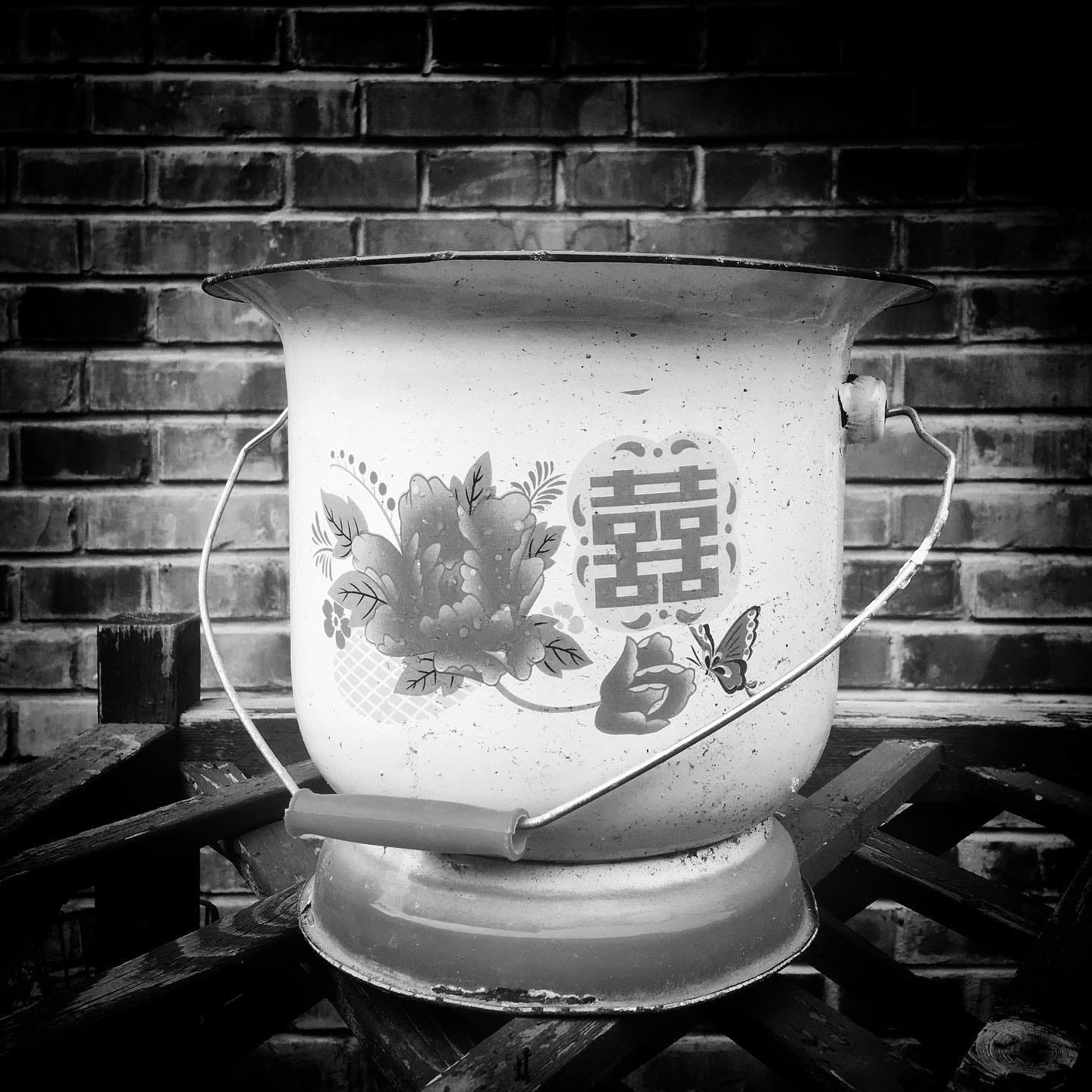 Old enamel chamber pot with the double happiness 囍 (shuāngxǐ) character, once a functional everyday item in Chinese households. Spotted in a Beijing hutong. Old enamel chamber pot with the double happiness 囍 (shuāngxǐ) character, once a functional everyday item in Chinese households. Spotted in a Beijing hutong.