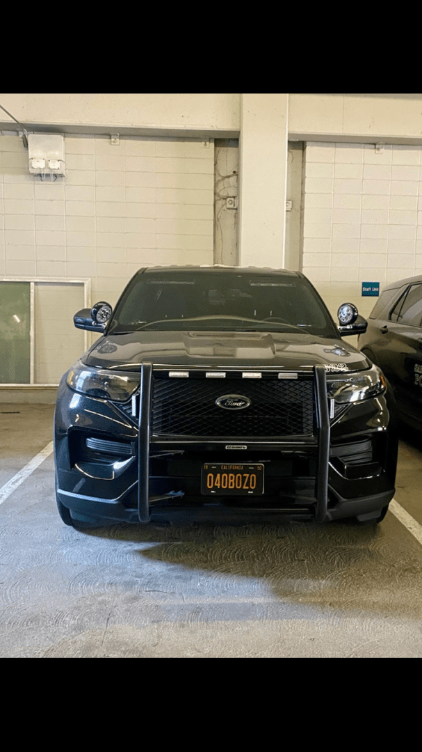 Front of a black Ford SUV with a license plate that reads 040BOZO