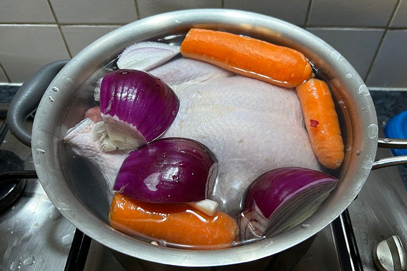 Making chicken stock with carrots and onions.