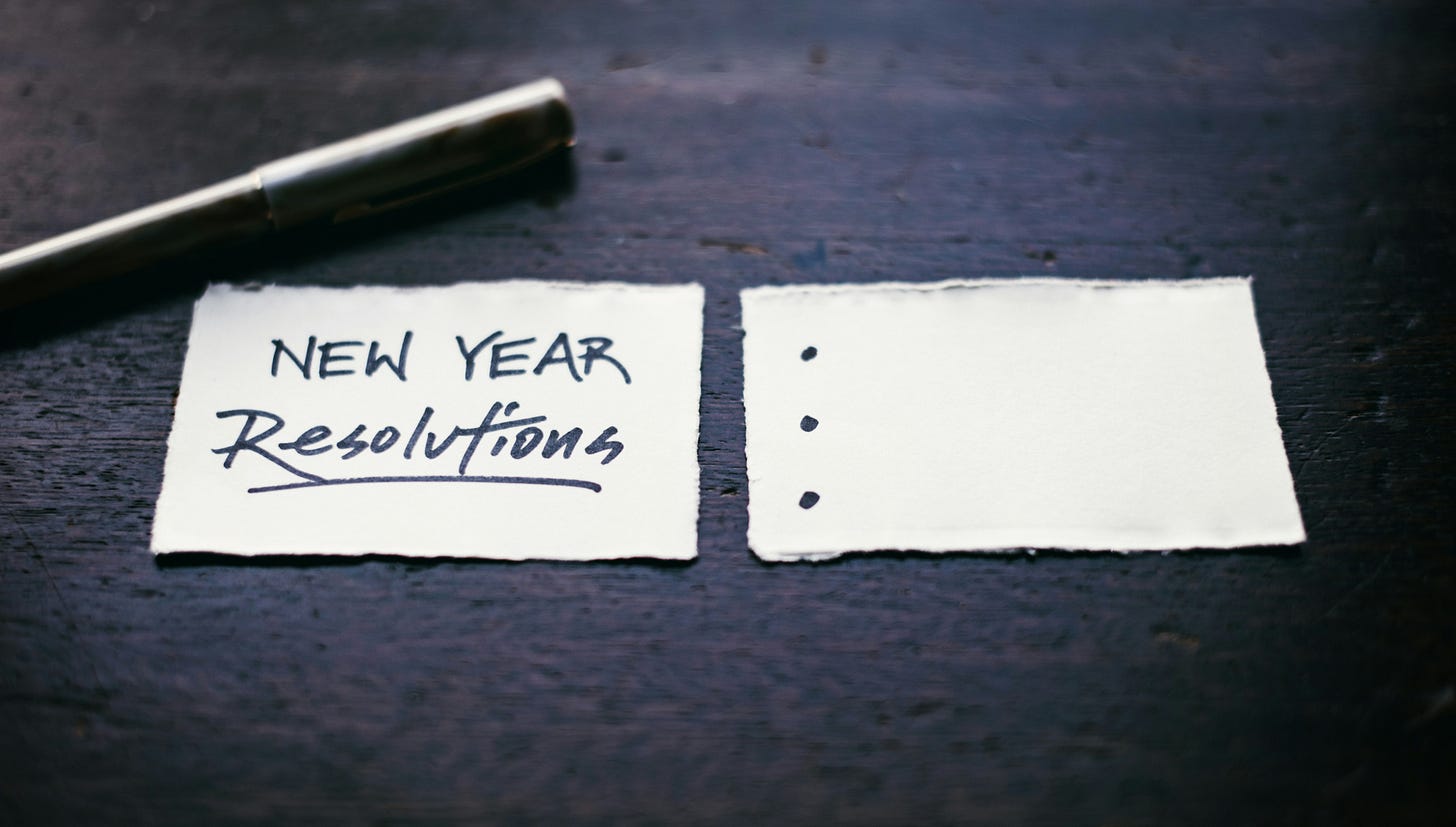 Photo of two pieces of paper and a pen on a table. The left hand piece says New Year Resolutions and the right has three blank bullet points. Photo of two pieces of paper and a pen on a table. The left hand piece says New Year Resolutions and the right has three blank bullet points.