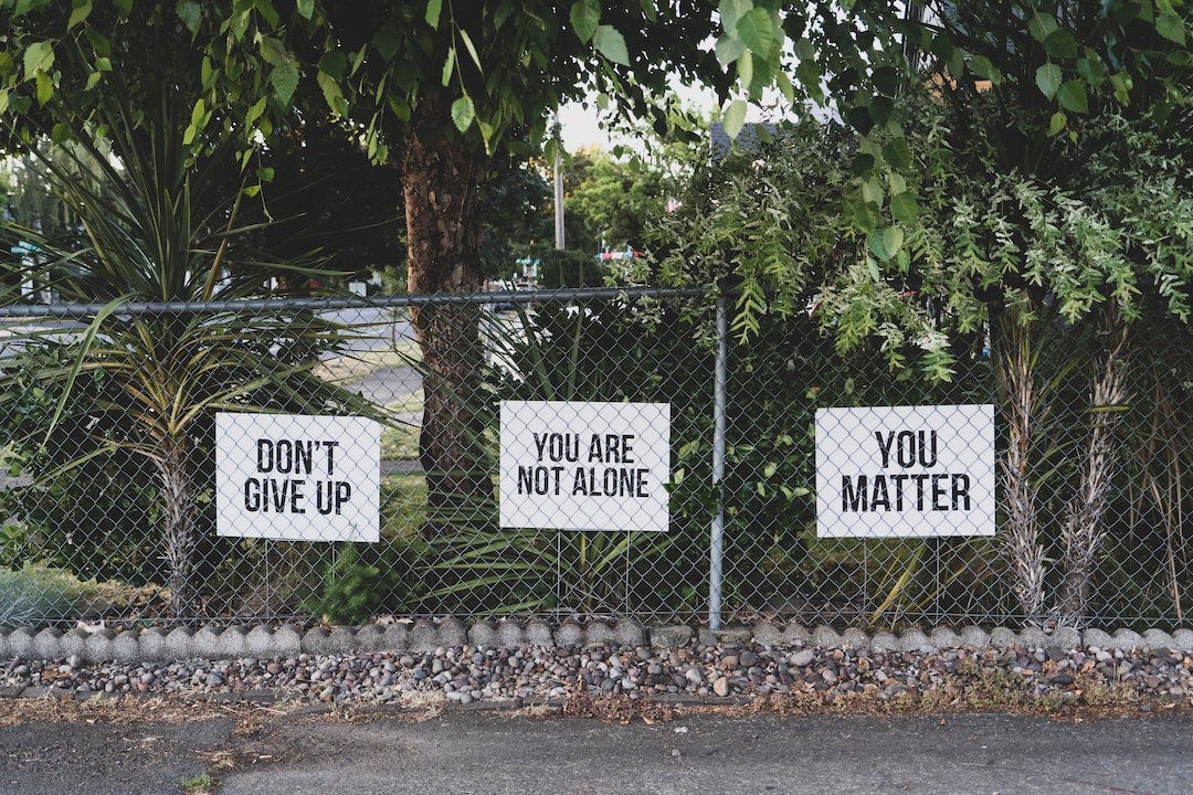 don't give up. You are not alone, you matter signage on metal fence don't give up. You are not alone, you matter signage on metal fence