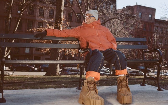 Spike Lee in Mschf 2x4 boots on a park bench.