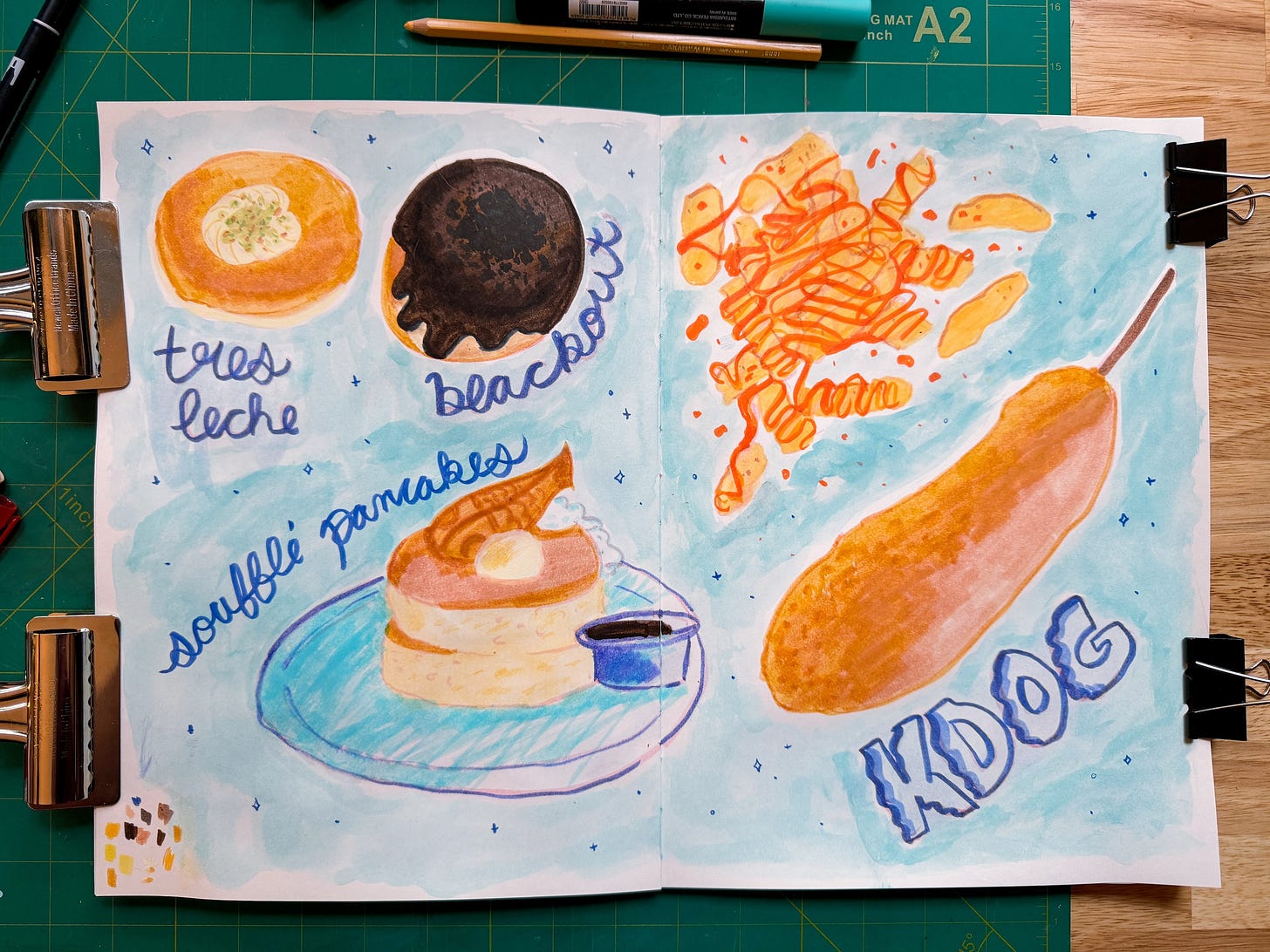 sketchbook spread of various food items including donuts, pancakes, fries and a korean corn dog