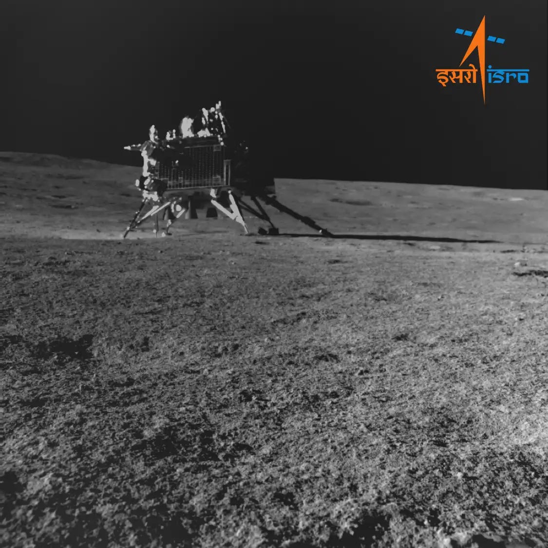 A black-and-white image of a squat lunar lander sitting on the surface of the Moon
