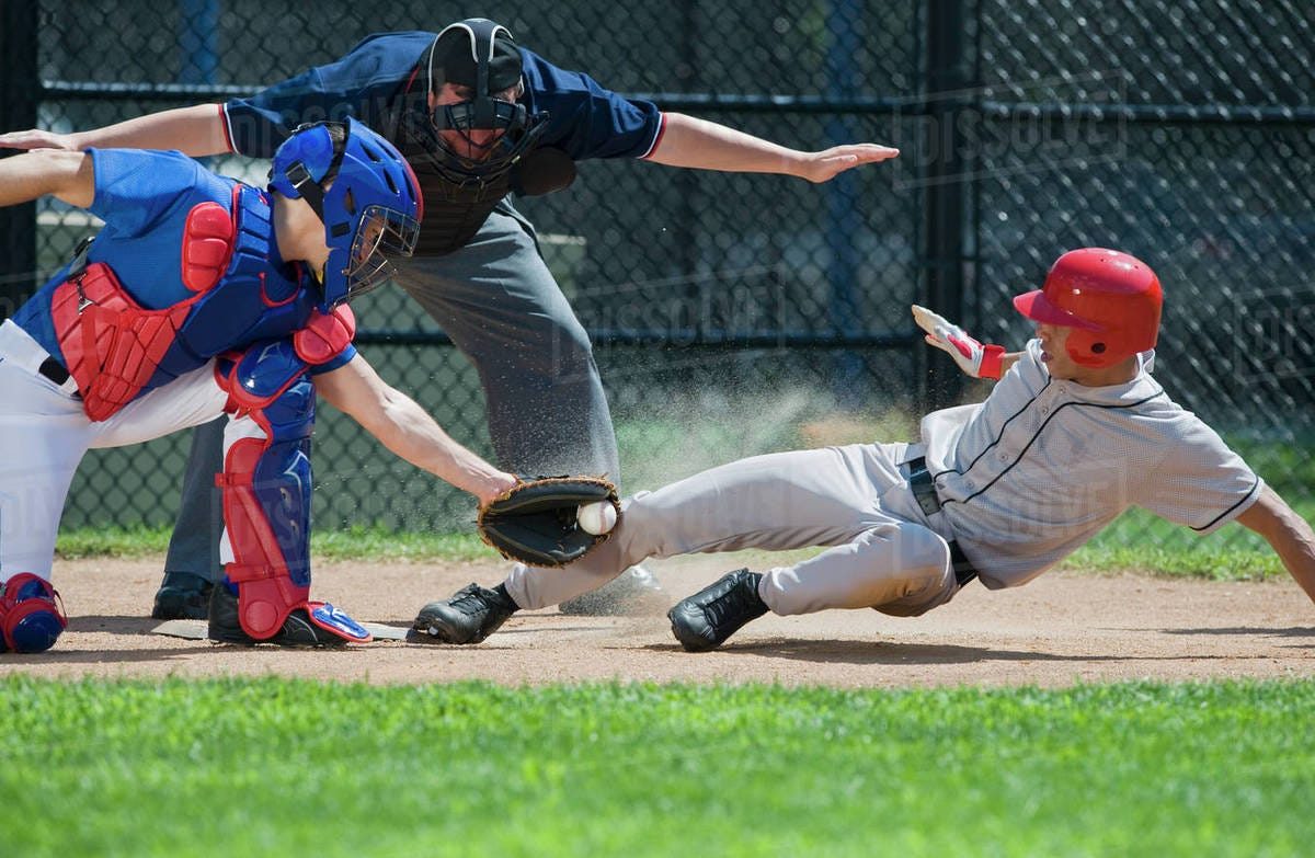 Baseball player sliding into home plate - Stock Photo - Dissolve