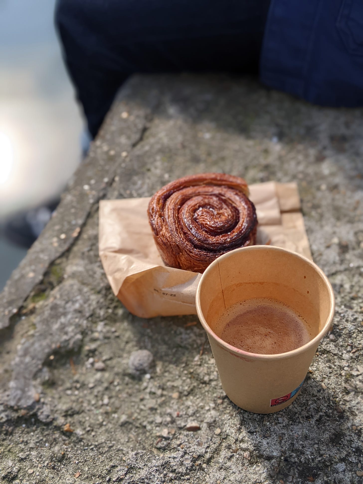 Coffee and cinnamon bun along the canal Saint Martin in Paris, France