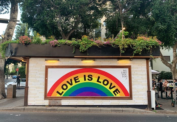 A painted rainbow banner proclaiming, “Love is love” A painted rainbow banner proclaiming, “Love is love”