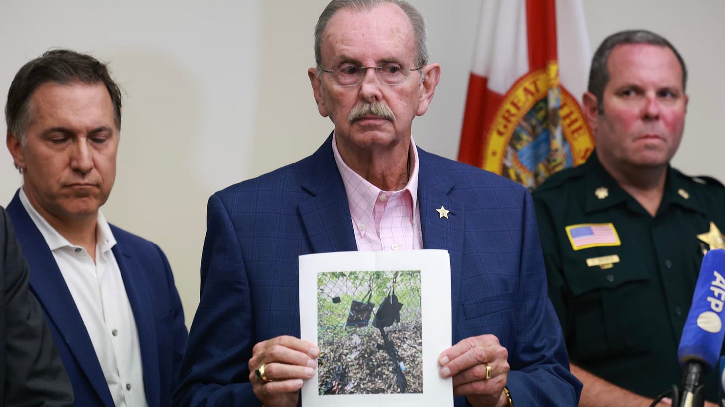 WEST PALM BEACH, FLORIDA - SEPTEMBER 15: Palm Beach County Sheriff Ric Bradshaw holds a photograph of the rifle and other items found near where a suspect was discovered during a press conference regarding an apparent assassination attempt of former President Donald Trump on September 15, 2024 in West Palm Beach, Florida. The FBI and U.S. Secret Service, along with the Palm Beach County Sheriff's office, are investigating the incident, which the FBI said "appears to be an attempted assassination of former P