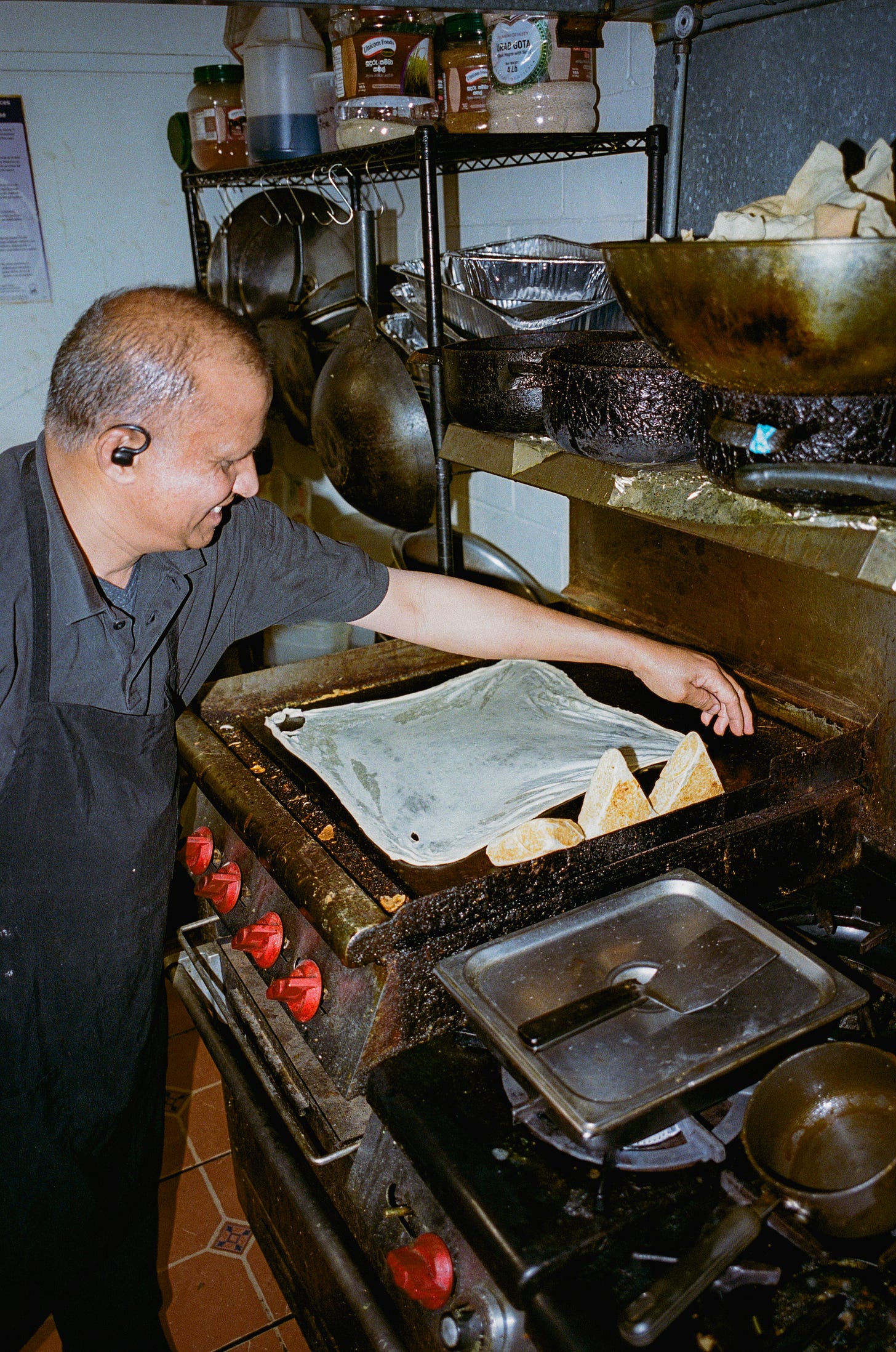 Kumar griddles dosa in the kitchen of Baja Subs