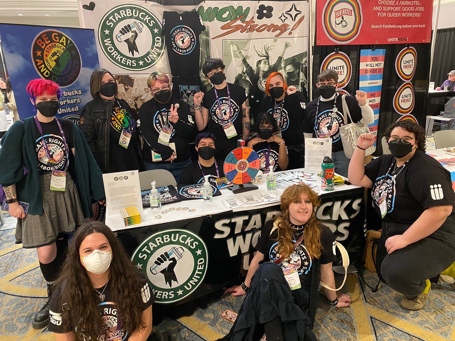 A large group of Starbucks workers pose in front of their booth at Creating Change in New Orleans