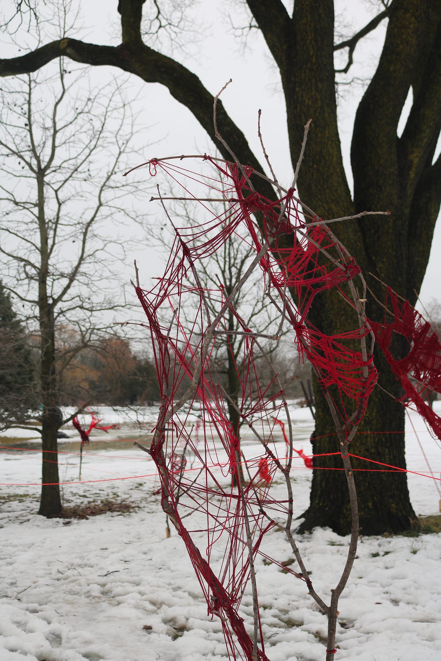 a close up of the installation. two of the scepters near each other creating a beautiful shape. the red pops against the dull grey of the scene.