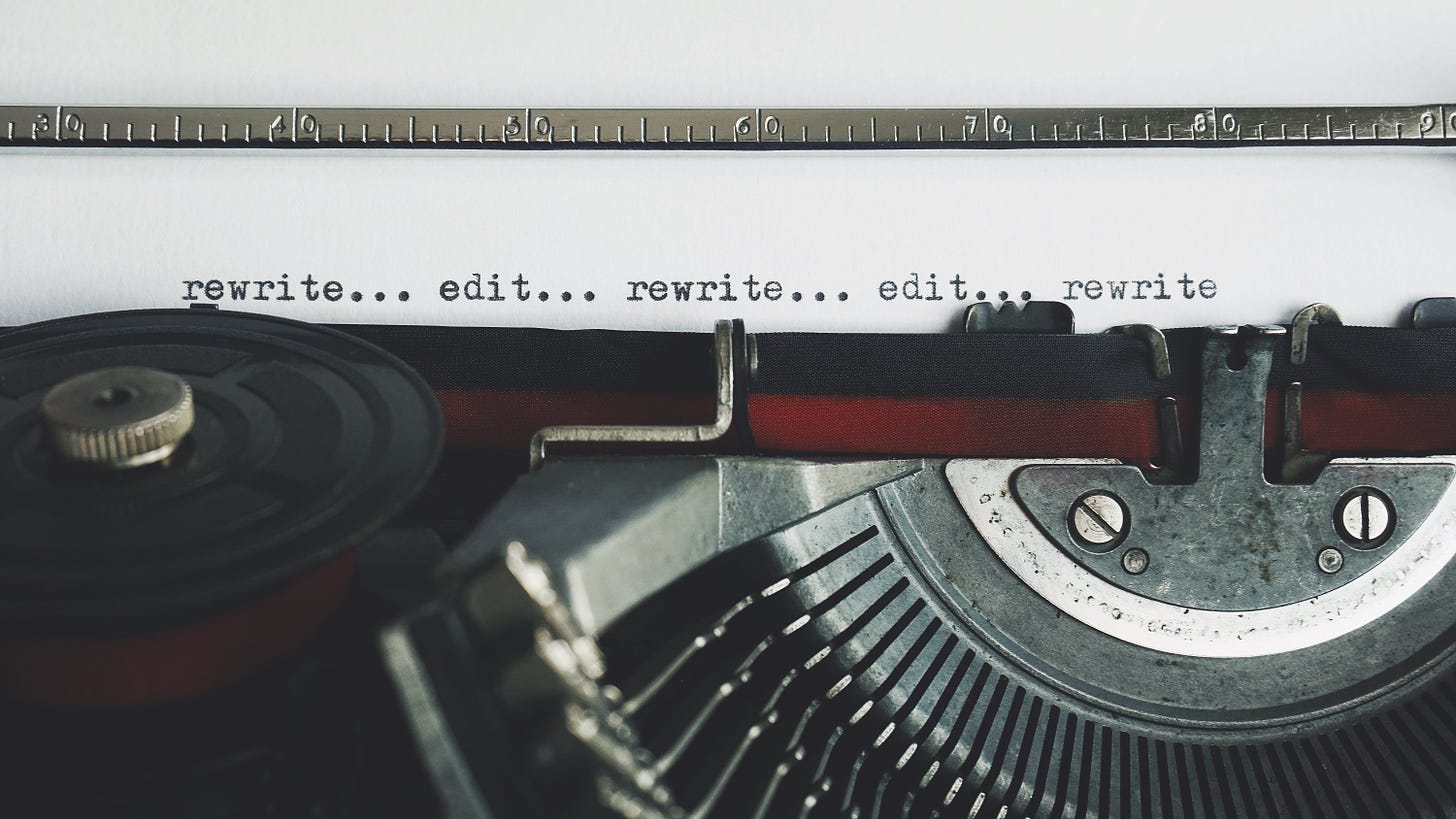 A typewriter that has written the words "rewrite...edit...rewrite...edit"