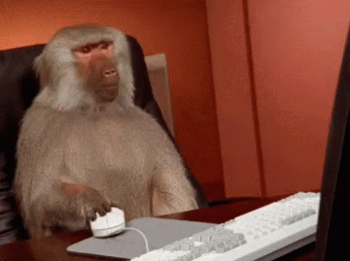 An animated gif of a monkey repeatedly clicking a computer mouse