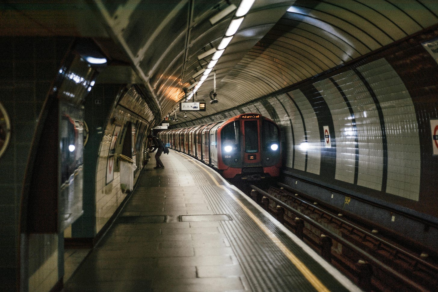 Incoming train at a London Underground platform with a platform hump. The platform is higher in the middle than at both ends of the platform.