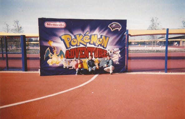 Paul and his friends posing in front of the Pokémon Adventure sign