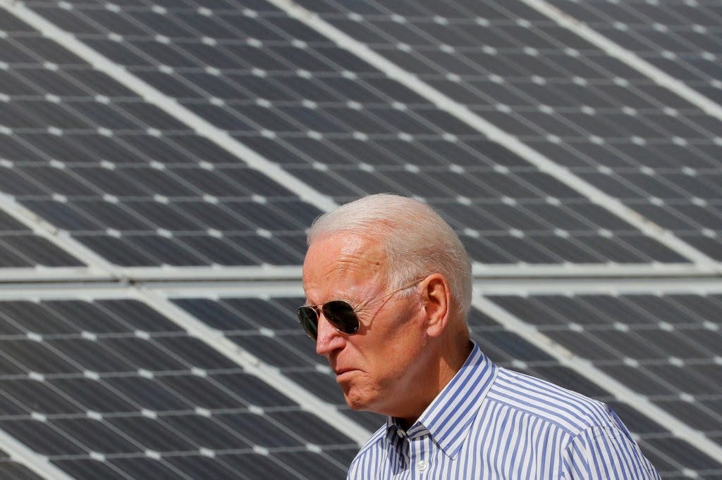 Democratic 2020 U.S. Presidential candidate Joe Biden walking past solar panels while touring the Plymouth Area Renewable Energy Initiative
