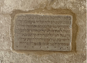 A stone plaque with text on it

Description automatically generated