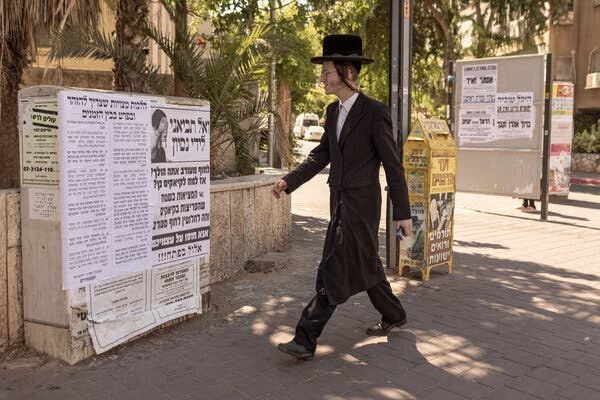 A person walks near signs displayed in a public space.