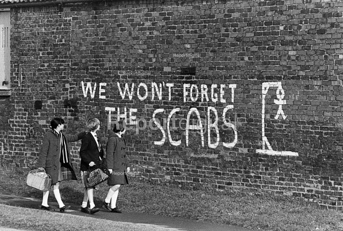Children walking past graffiti We Wont Forget The Scabs.....