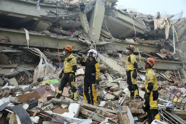 In this photo released by Xinhua News Agency, Chinese rescuers looks at a collapsed building before conducting a search and rescue operation in the aftermath of an earthquake in Mandalay, Myanmar, Sunday, March 30, 2025. (Myo Kyaw Soe/Xinhua via AP)