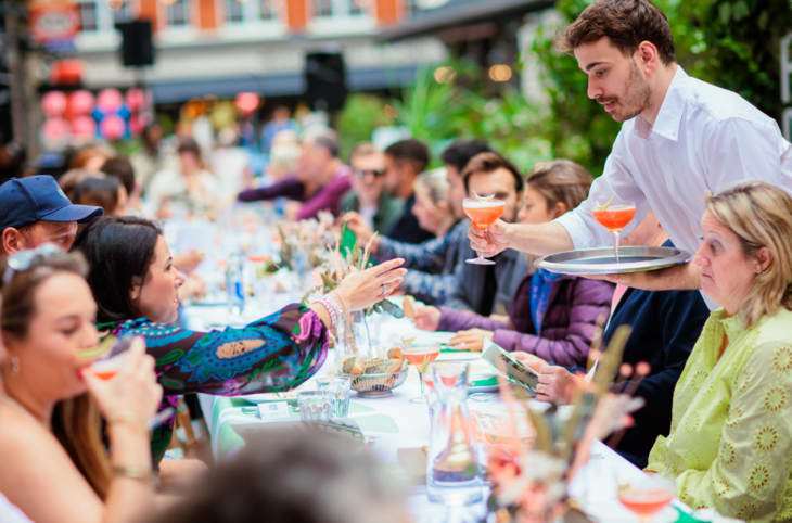 A man serving up cocktails to a long table