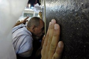 A Hajj pilgrim kisses the Ka'bah.