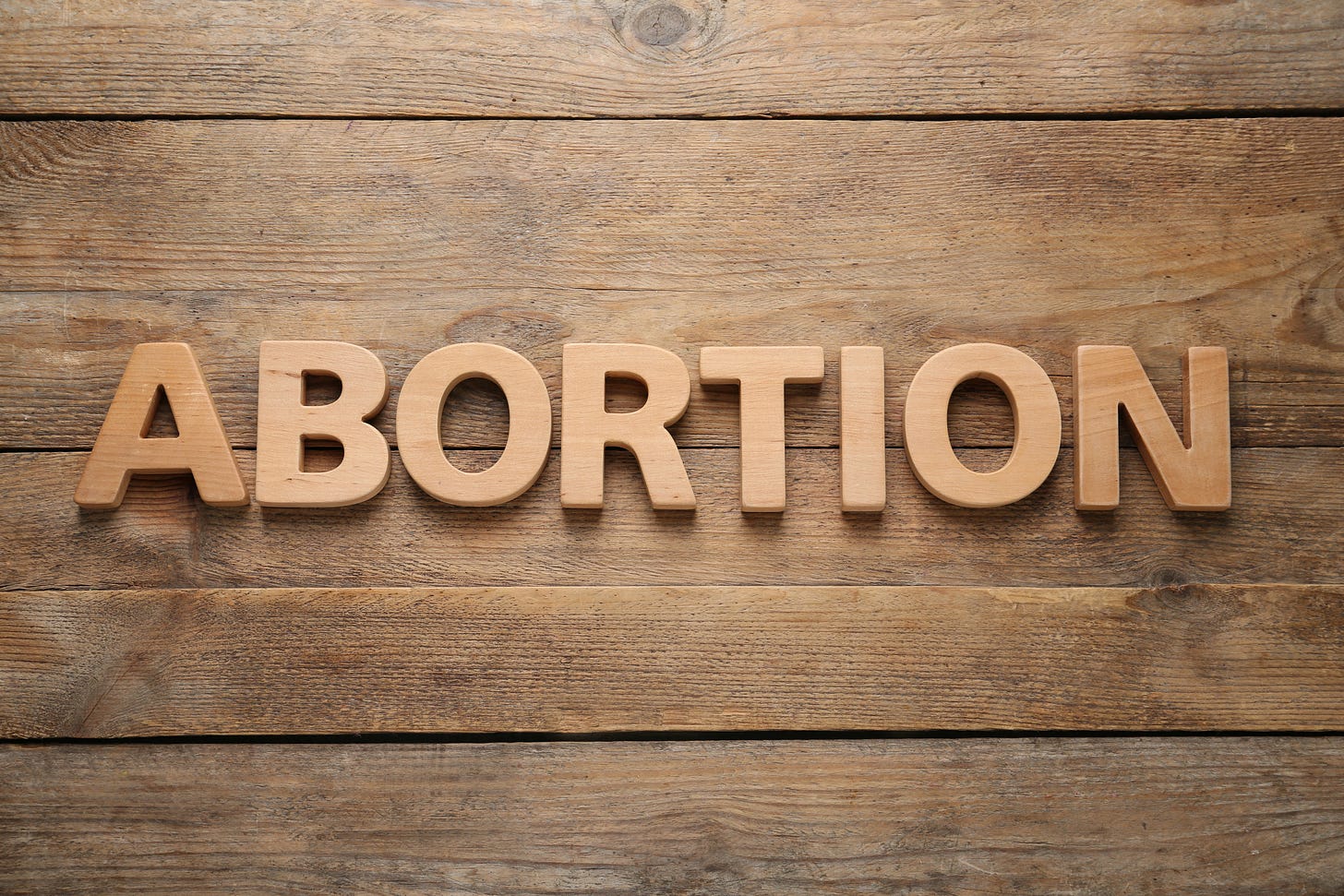 The word 'abortion' on wood. Abortion to save the life of the mother