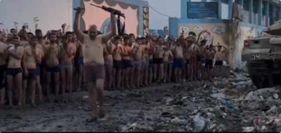 The moment a man hands over his assault rifle during what Israel claims is a mass surrender of Hamas operatives