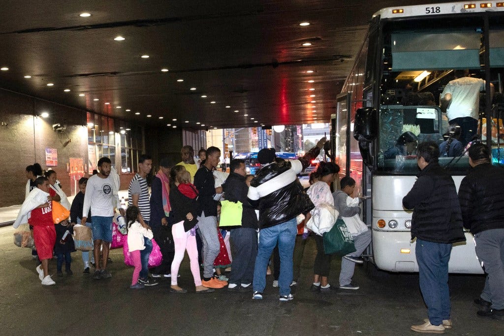 Migrants get on a bus at the Port Authority Bus Terminal in Manhattan on Oct. 10, 2023. 