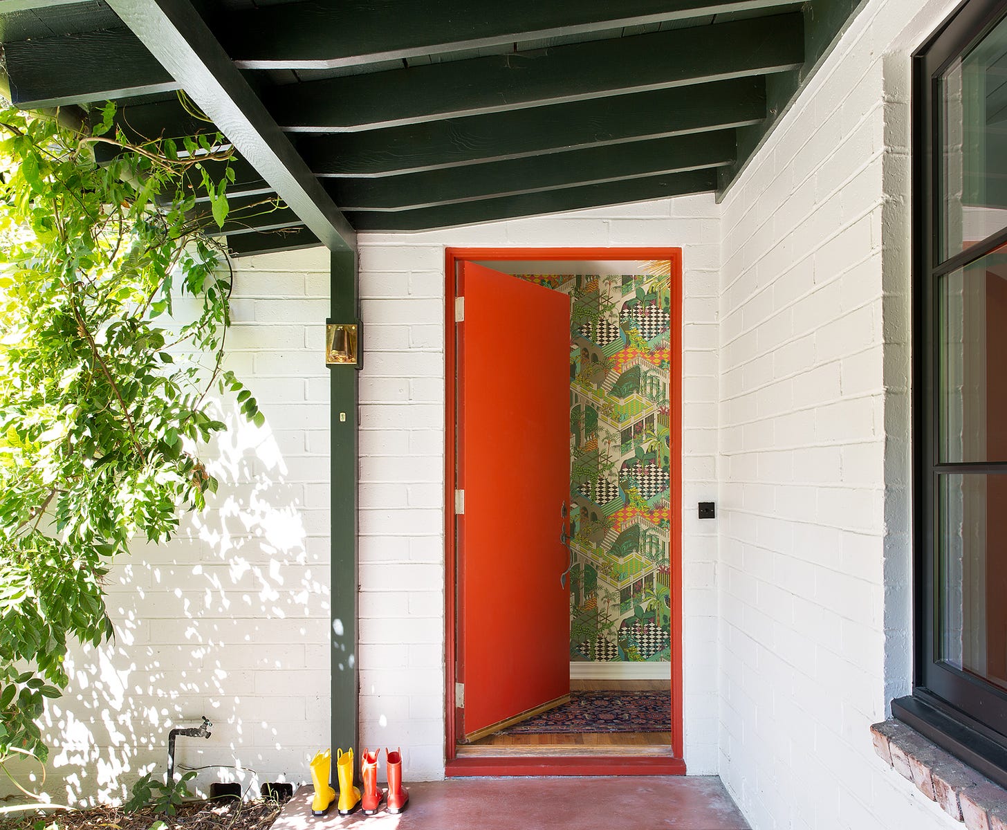 Entrance to midcentury modern home with a red door