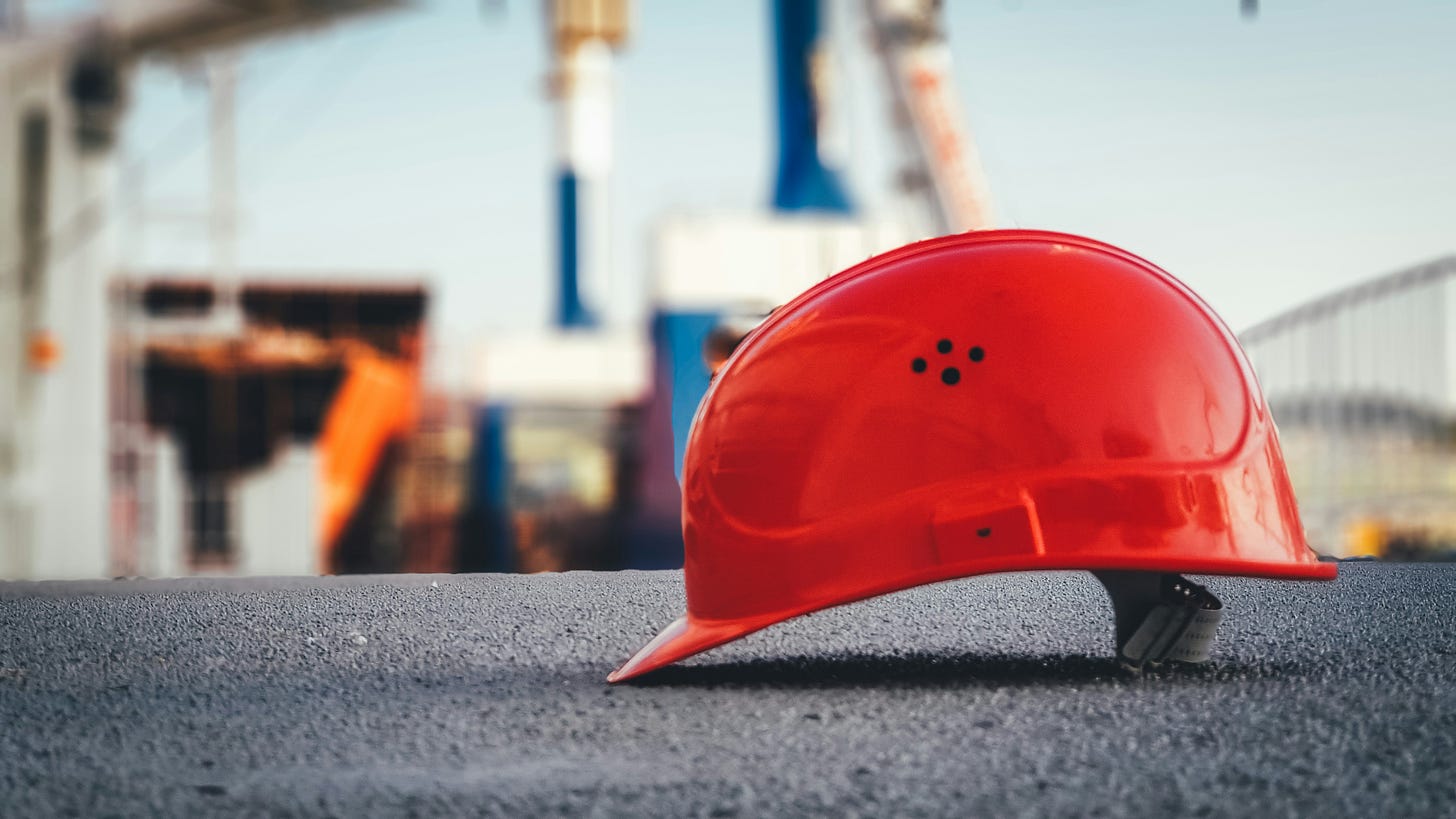 hard hat on concrete in front of construction