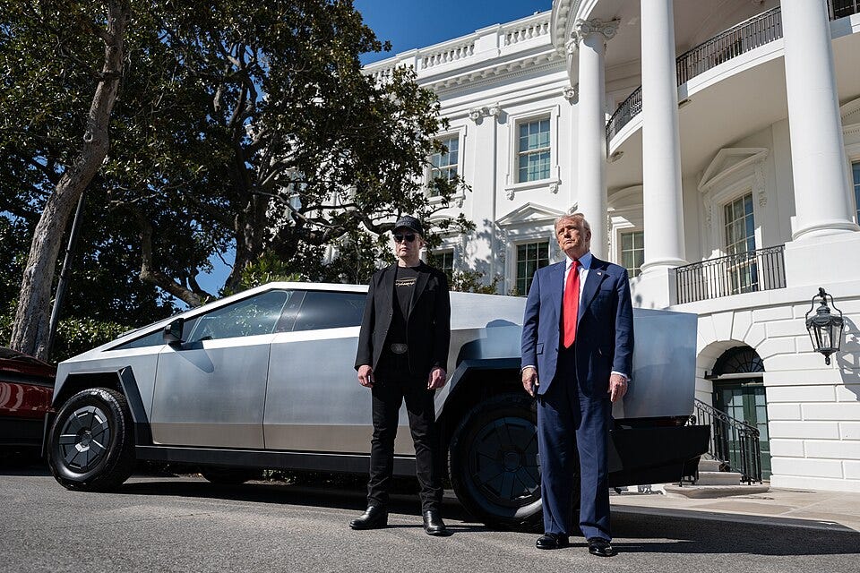 Elon Musk and Donald Trump stand in front of a Cybertruck, which itself is parked directly in front of the White House Elon Musk and Donald Trump stand in front of a Cybertruck, which itself is parked directly in front of the White House