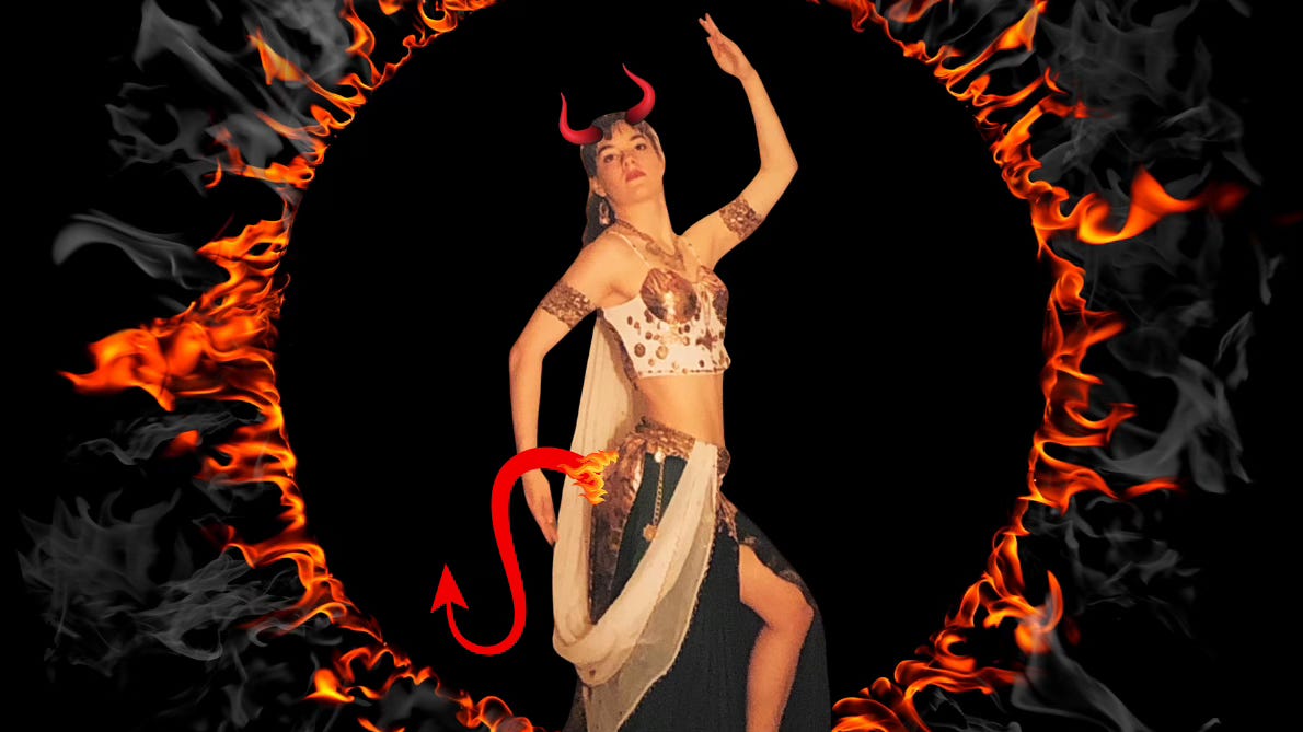 The author in a white, gold, and green belly dance costume, with devil horns and tail. Naturally, she stands inside a ring of fire surrounding the black abyss, from which she hails.