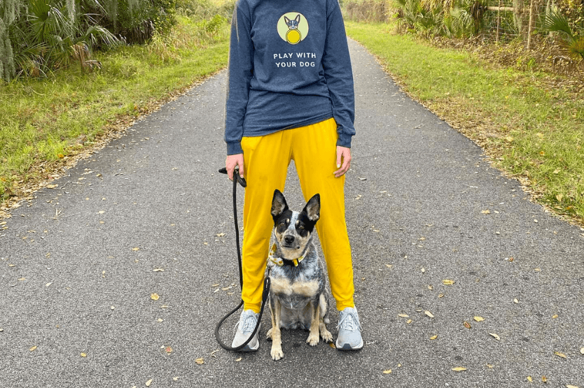 Scout the Australian cattle dog posing between her owner's legs on the dog-friendly Brevard Linear Zoo Trail