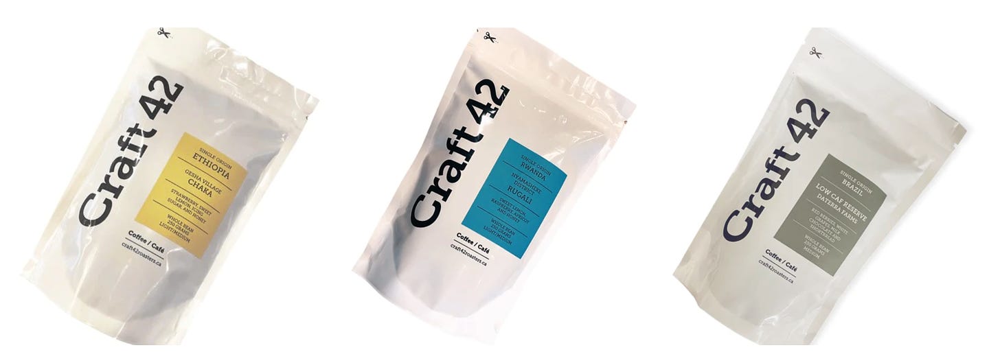 White coffee bags with labels in blue, yellow, or green on a white background.